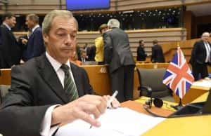 FILE - A Tuesday, June 28, 2016 image from files showing the leader of the United Kingdom Independene Party, Nigel Farage, sitting next to a British flag during a special session of European Parliament in Brussels. Farage announced Monday, July 4, 2016 that he is resigning as leader of the party. (AP Photo/Geert Vanden Wijngaert, File)