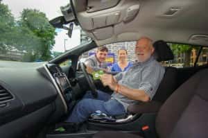 Jonathan Adams a member of the Co-Wheels Car Club seated in one of their cars in Cowan Terrace, Sunderland with Councillor Michael Mordey (left) Sunderland City Council Portfolio Holder for City Services Liz Gray Co-Wheels North Regional Manager.